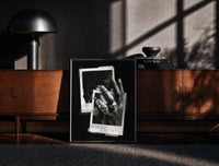 Black-framed ASAP Rocky At Long Last Rings print on the floor in front of a dark wooden console