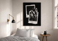 ASAP Rocky At Long Last Rings print in a black frame above a bed with striped linens, a brass wall lamp and a sunlit window