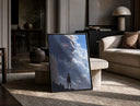 Soldier facing colossal titan print in a black frame leaning on a travertine table in a sunlit lounge