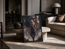 Anime warrior with red scarf and titan print in a black frame leaning on a travertine table in a sunlit lounge