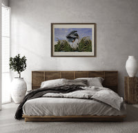 Great blue heron in marsh print in a dark wood frame above a rattan bed on a plaster wall