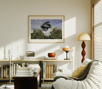 Great blue heron in marsh print in an oak frame above a mid-century book console with a vintage radio