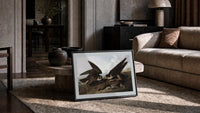 Two peregrine falcons with prey print in a slim black frame leaning on a travertine coffee table