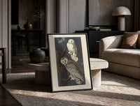 Two snowy owls on branch print in a black frame leaning on a travertine table in a sunlit lounge