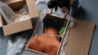 Back View Fastening a Necklace framed print being unpacked from protective bubble wrap and a box