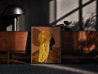 Black-framed Back View in a Gold Durag print on the floor in front of a dark wooden console