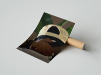 Gently curled Backwards Cap with an Embracing Hand print beside its protective shipping tube