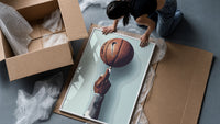 Basketball Balanced on a Fingertip framed print being unpacked from protective bubble wrap and a box