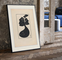 Woman in black gown and hat print in a black frame leaning beside a vintage door on parquet