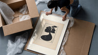 Woman in black gown and hat framed print being unpacked from protective bubble wrap and a box