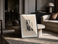 Two Art Nouveau figures embracing print in a black frame leaning on a travertine table in a sunlit lounge