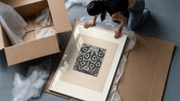 Peacock feather title page design framed print being unpacked from protective bubble wrap and a box