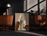 Black-framed Beige Sneakers and White Socks print on the floor in front of a dark wooden console