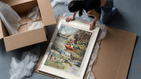 Woman rowing boat on lake framed print being unpacked from protective bubble wrap and a box