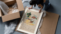 Birds on branch with holly framed print being unpacked from protective bubble wrap and a box