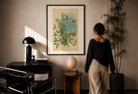Birds Wishing You a Merry Christmas print in a black frame on a sunlit wall with a viewer