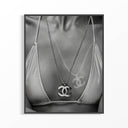 Black and white close-up of a Chanel CC pendant necklace over a bikini top with graffiti detail