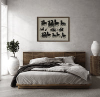 Group of black horses print in a dark wood frame above a rattan bed on a plaster wall