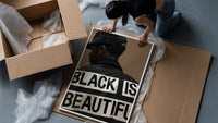 Black Is Beautiful Cap framed print being unpacked from protective bubble wrap and a box