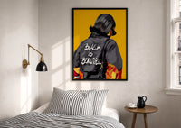Black Is Beautiful Flame Jacket print in a black frame above a bed with striped linens, a brass wall lamp and a sunlit window