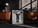 Black-framed KAWS Companion figure standing print on a moody console with designer coffee-table books