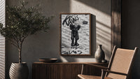 Head-bowed KAWS Companion poster framed above a fluted sideboard beside an olive tree