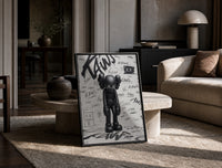Head-bowed KAWS Companion print in a black frame leaning on a travertine table in a sunlit lounge