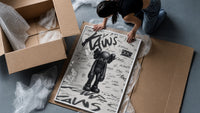Head-bowed KAWS Companion framed print being unpacked from protective bubble wrap and a box
