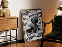 Brass-framed Black KAWS Companion figure sitting print leaning in a warm styled corner by a sculpture
