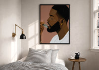 Black Man Combing His Beard print in a black frame above a bed with striped linens, a brass wall lamp and a sunlit window