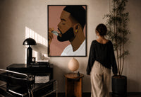 Black Man Combing His Beard print in a black frame on a sunlit plaster wall, a woman looking on beside a mushroom lamp