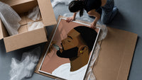 Black Man Combing His Beard framed print being unpacked from protective bubble wrap and a box