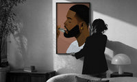 Black Man Combing His Beard print in a slim black frame being hung on a sunlit wall in a monochrome room