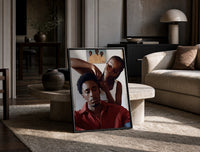 Black Man Having His Hair Braided print on the floor, leaning against a travertine table