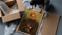 Black Man in Brown Baseball Cap framed print being unpacked from protective bubble wrap and a box