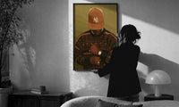 Black Man in Brown Baseball Cap print in a slim black frame being hung on a sunlit wall in a monochrome room