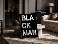 Black Man Lettering print on the floor, leaning against a travertine table