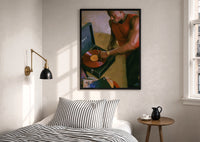 Black Man Playing a Vinyl Record print in a black frame above a bed with striped linens