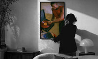 Black Man Playing a Vinyl Record print in a slim black frame being hung on a sunlit wall in a monochrome room