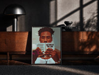 Black-framed Black Man Reading a Paperback print on the floor in front of a dark wooden console