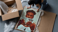 Black Man Reading a Paperback framed print being unpacked from protective bubble wrap and a box