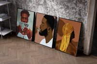 Black Man Reading and Grooming Set of 3 as black-framed prints leaning against a raw-plaster wall