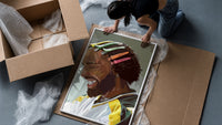 Black Man with Colorful Hair Clips framed print being unpacked from protective bubble wrap and a box