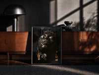 Black-framed Black Man with Gold Drop Earrings print on the floor in front of a dark wooden console