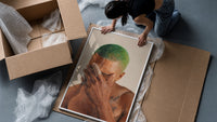 Black Man with Green Hair framed print being unpacked from protective bubble wrap and a box