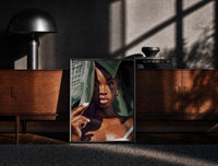 Black Woman with Tropical Leaves print on the floor in front of a dark wooden console