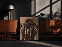 Black-framed Black Woman Holding Her Braids print on the floor in front of a dark wooden console