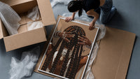Black Woman Holding Her Braids framed print being unpacked from protective bubble wrap and a box