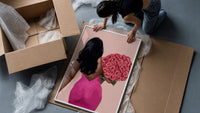 Black Woman Holding Pink Roses framed print being unpacked from protective bubble wrap and a box