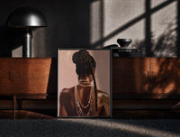 Black-framed Black Woman with a Braided Bun print on the floor in front of a dark wooden console